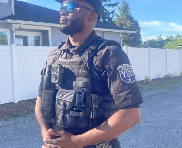 Licensed YARD Security Services officer in uniform and tactical vest with YSS patch